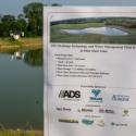 Sponsorship poster near drainage pond